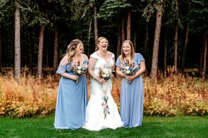 Small wedding party group photo with powder blue bridesmaid dresses in wooded setting.