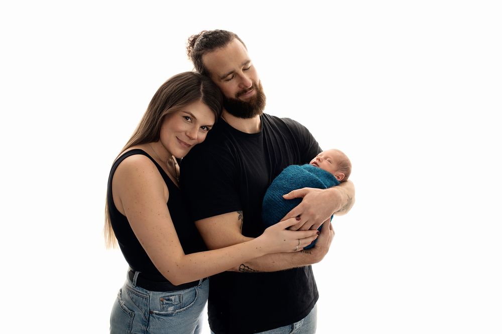 Exeter newborn specialist- safe family posing with newborn on white backdrop.