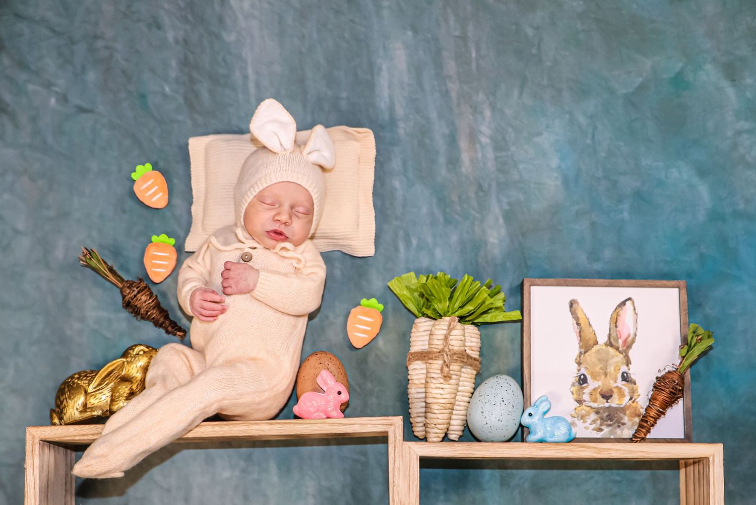 Easter-themed baby photo setup with bunny decorations and spring elements.