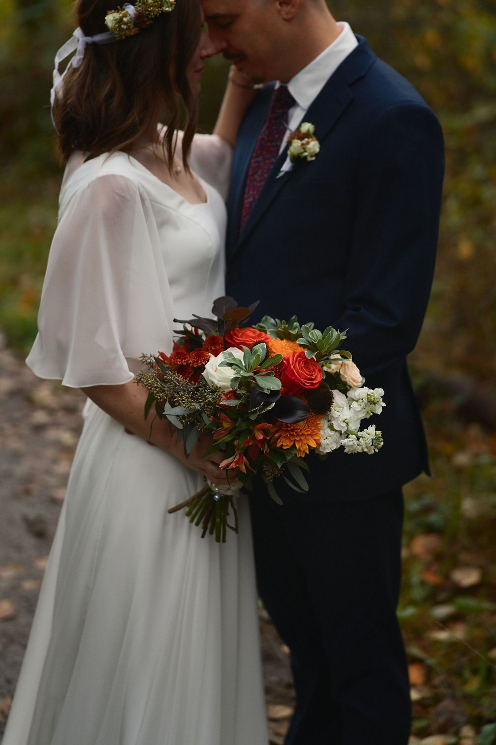 Moody photo of bride and groom resting foreheads together
