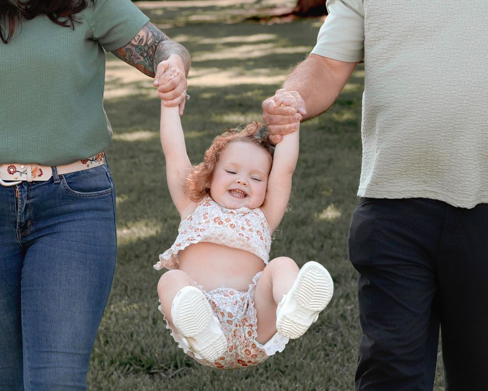 A sequence of candid outdoor photos showing joyful interactions between adults and a small child on a sunny day.