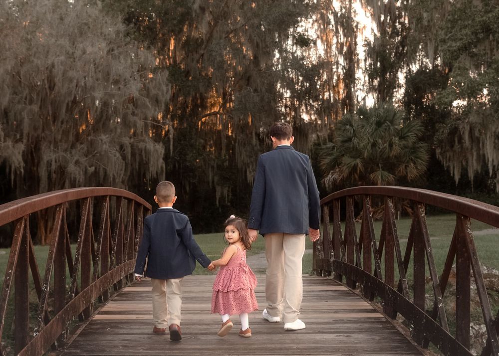 A sequence of photos showing a family walking along a wooden boardwalk path through a wooded area at sunset.