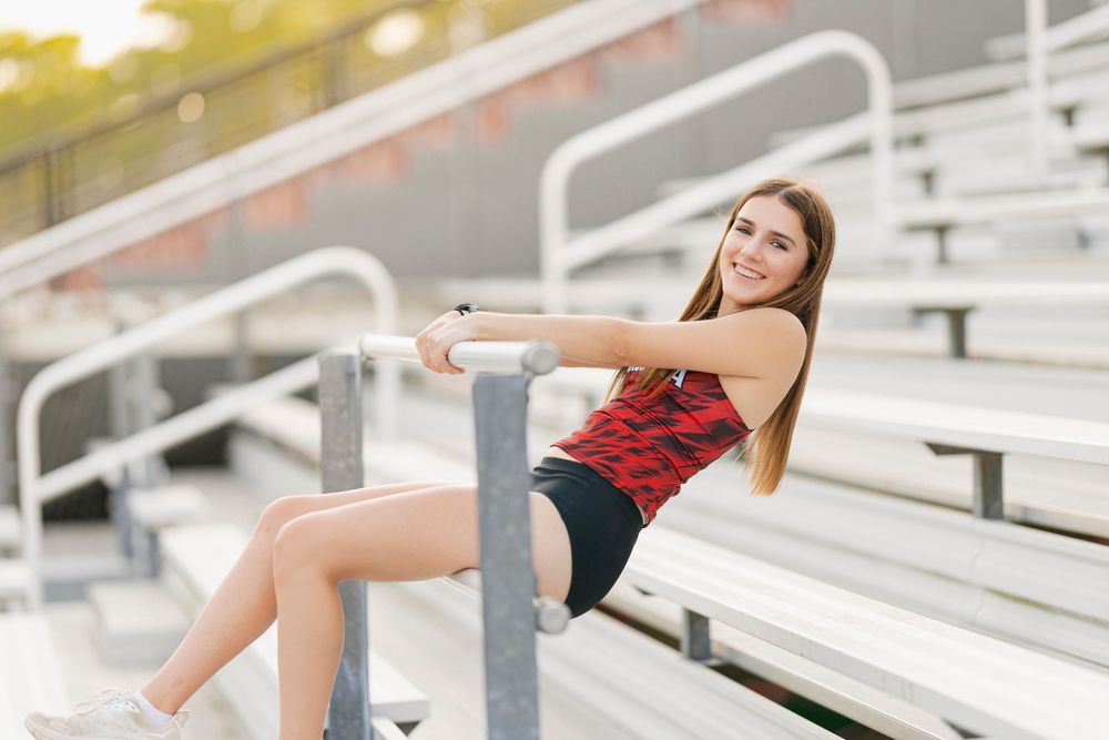 Athletic person demonstrating proper form for a tricep dip exercise on bleacher steps.
