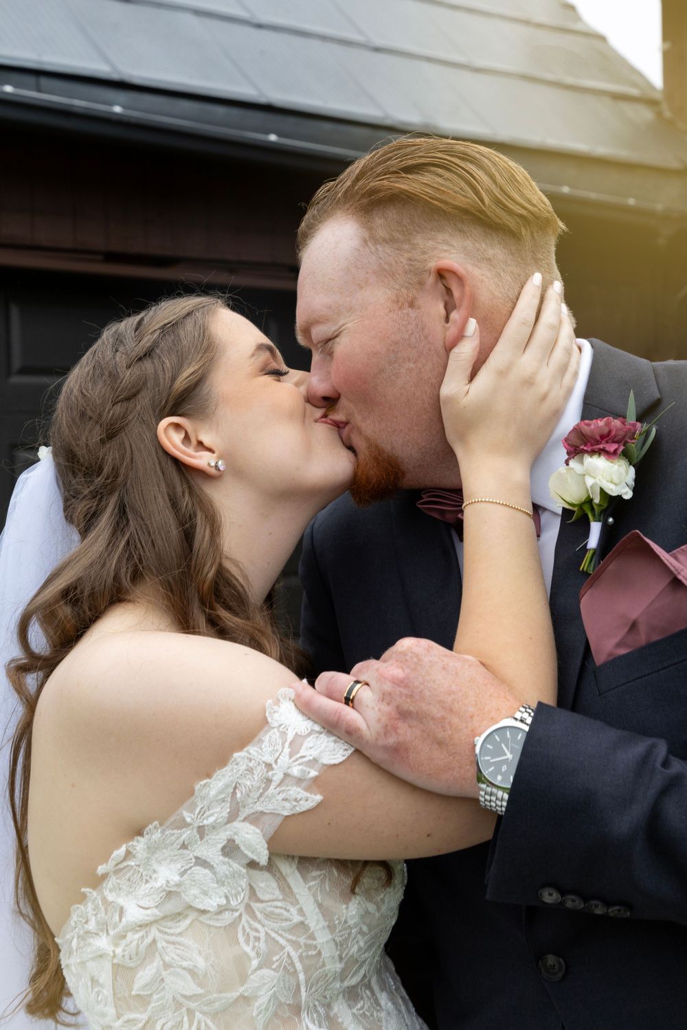 A close up shot of a bride and goom kissing, with the bride holding the back of her grooms head.