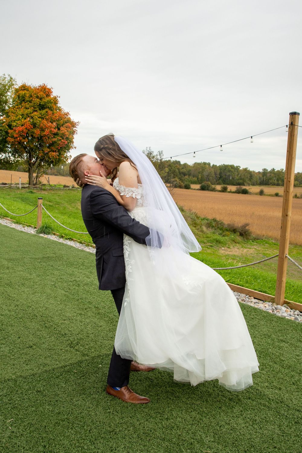 a groom picking up his bride and kissing her