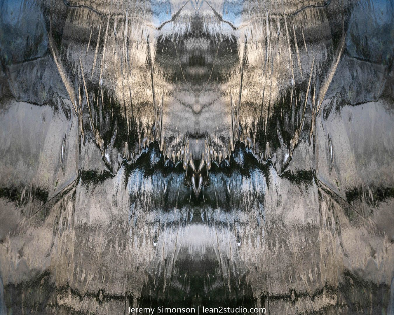 Abstract mirrored pattern in grayscale showing ice formations creating symmetrical designs.