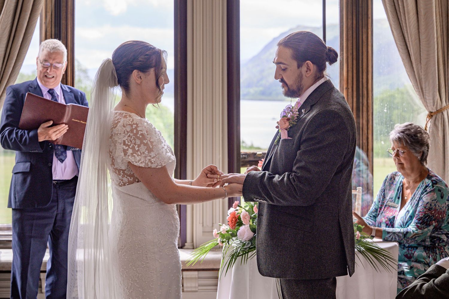 Bride and groom exchange rings at Armathwaite Hall wedding