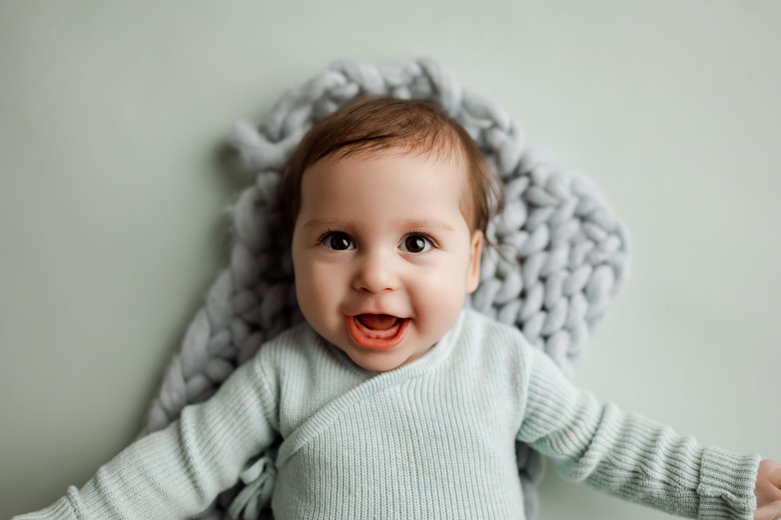 A series of candid baby portraits showing different expressions and poses against a light background.