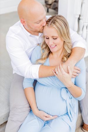 Intimate maternity portrait of couple on white porch in Springfield, Missouri.