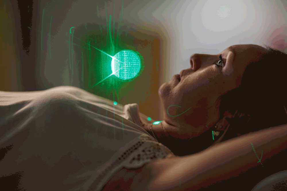Woman lying down gazing at a glowing green orb light in a dark, atmospheric room.