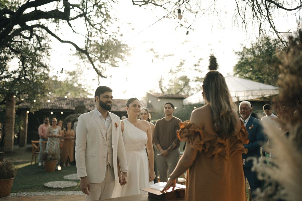 Wedding guests dance and celebrate outdoors at sunset during a joyful reception celebration.