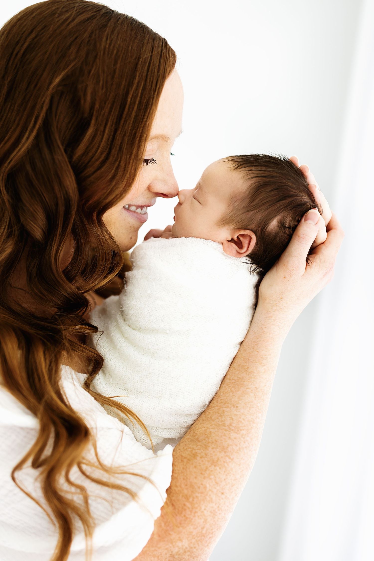 A tender moment captured in a series of four white minimalist photos showing affectionate parent-child interaction.