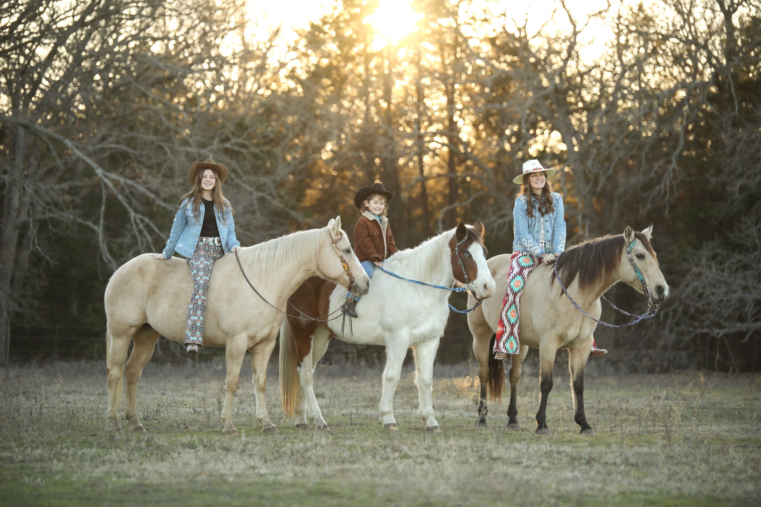 family equestrian portraits, three children sitting on their horses bareback in a field at sunset.