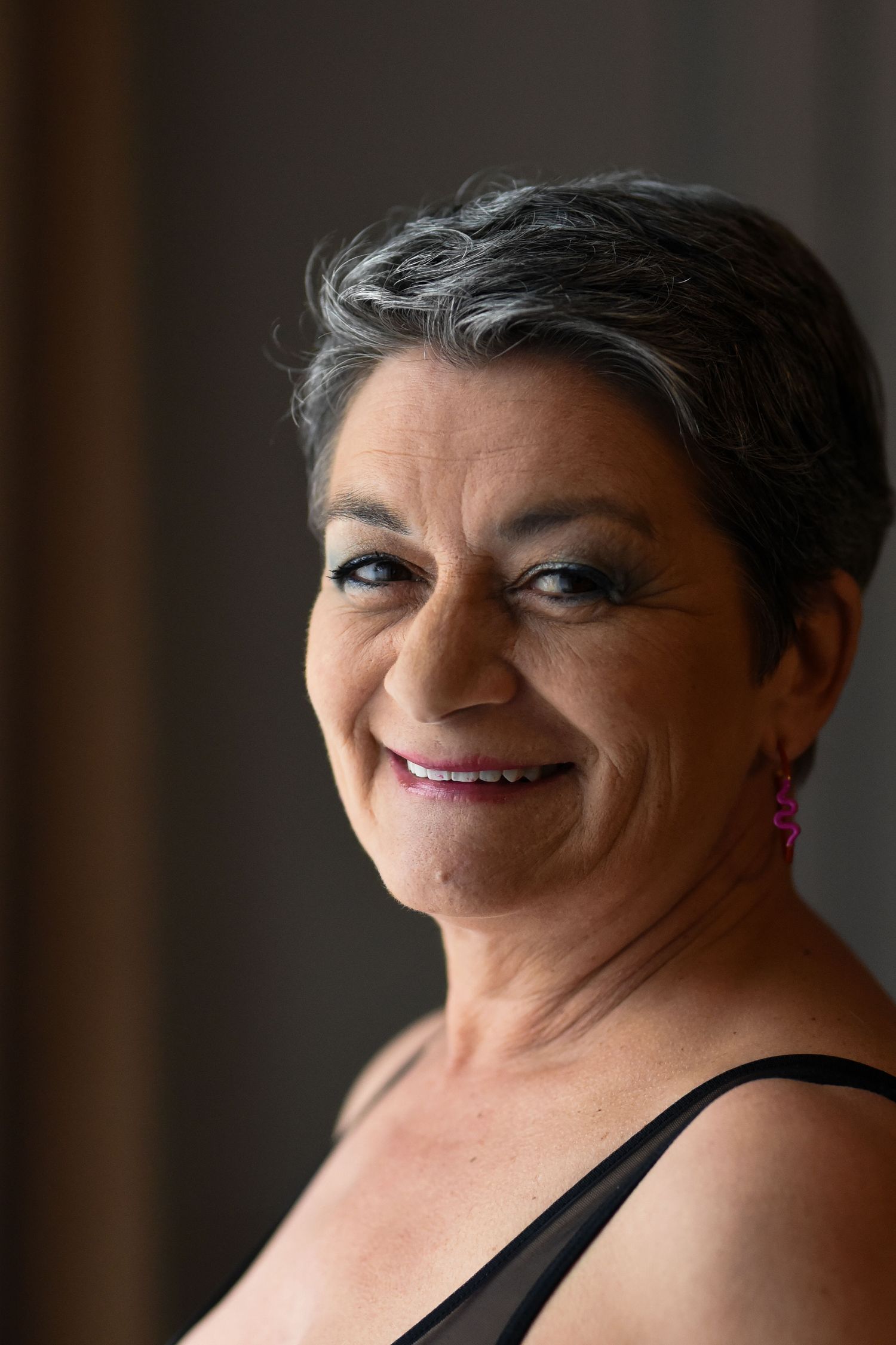 A series of four close-up portrait shots showing joyful expressions and genuine smiles in black attire.