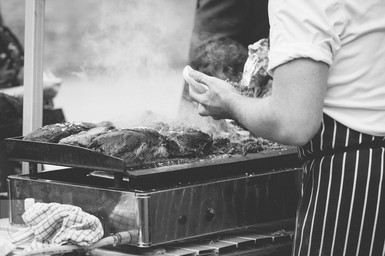 Reportage detail shot of wedding breakfast food service, an outdoor barbecue
