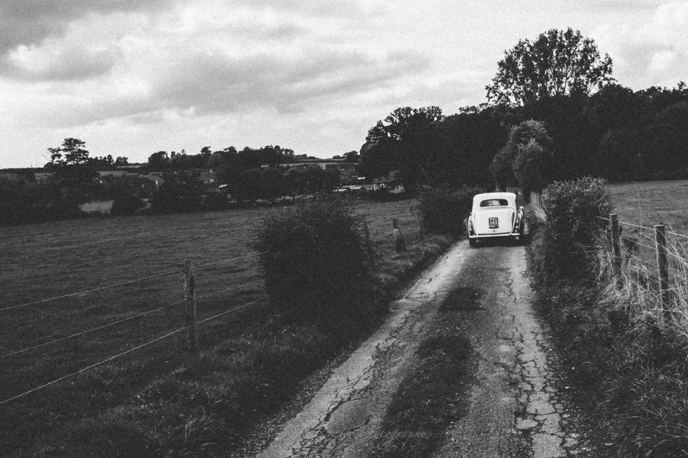 Reportage detail shot of October wedding bridal classic car along country road