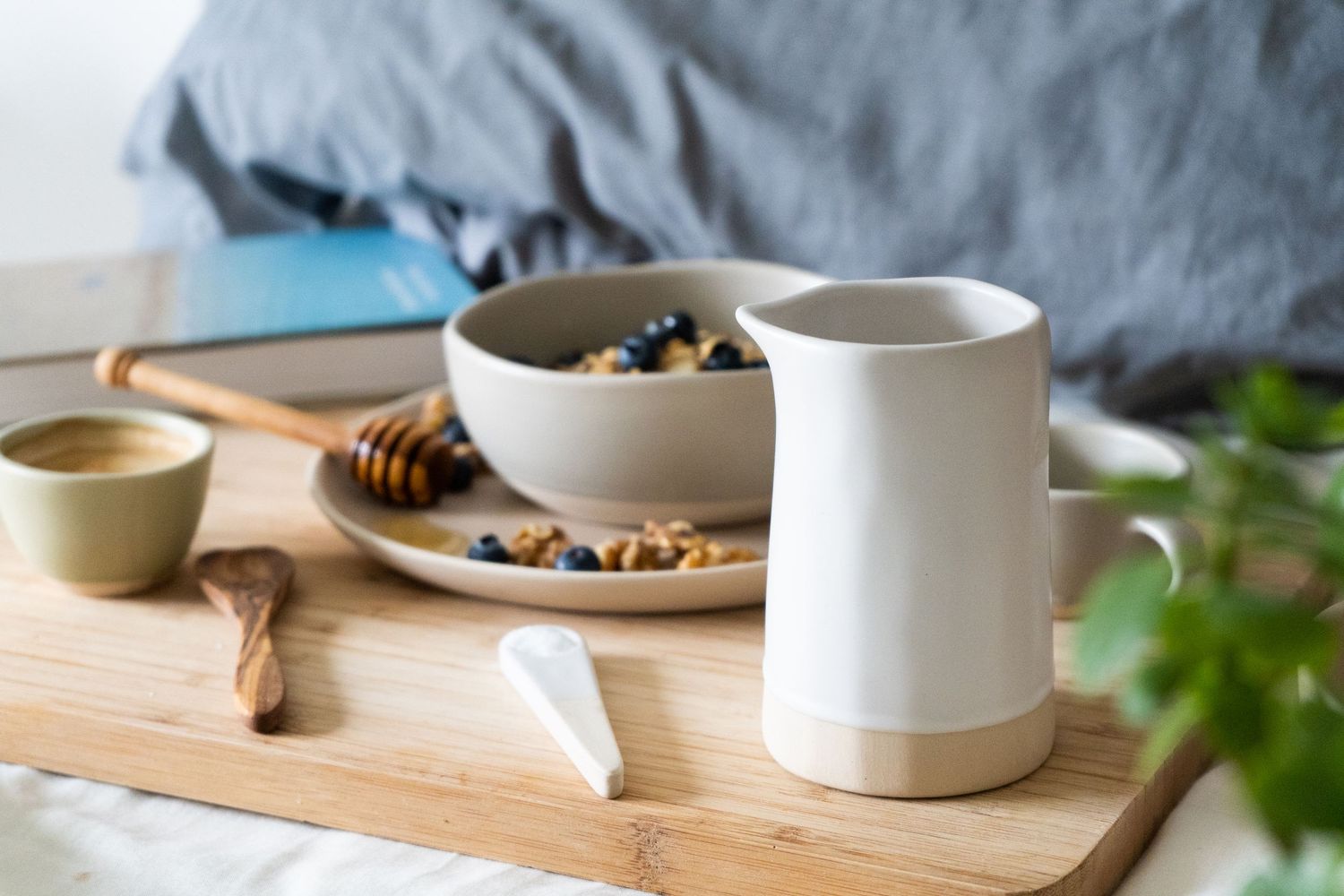 a lifestyle photo of a breakfast set up in bed with granola and berries