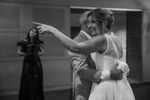 Black and white photo of a bride and groom sharing their first dance at their wedding reception.