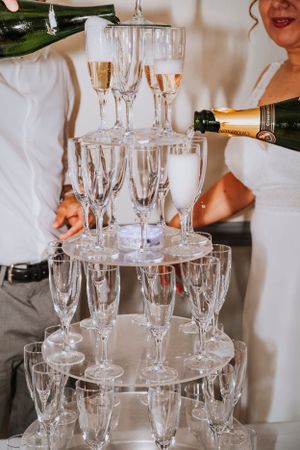 Crystal champagne glasses arranged in elegant tiers for a wedding celebration.