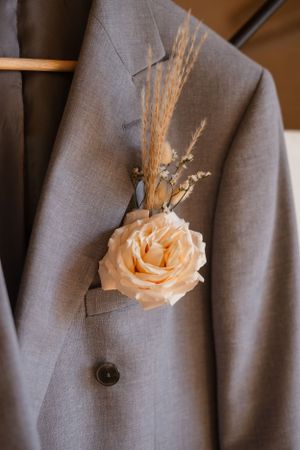 Multiple close-up shots of a peach rose boutonniere pinned to a gray suit jacket.