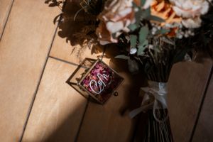 Peach and coral roses arranged with delicate dried flowers in a romantic wedding decor setting.
