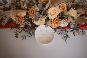 Overhead view of an elegant floral centerpiece with peach roses and greenery.