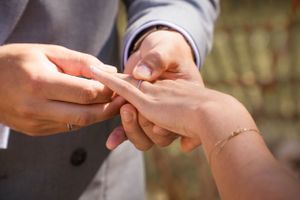 Close-up of hands exchanging rings during a wedding ceremony.