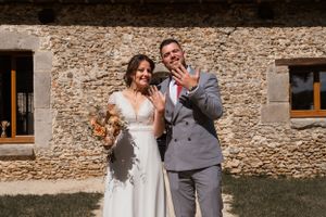 Newlyweds sharing a moment in front of a historic stone building.