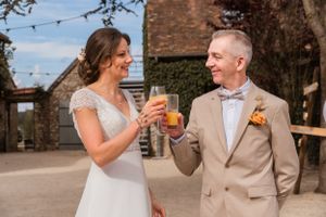 Couple enjoying drinks together at an outdoor rustic venue.