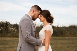 Romantic outdoor wedding portraits in a natural field setting.