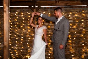 Wedding celebration in rustic venue with stone walls and string lights creating romantic ambiance.