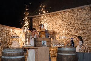 Stone-walled reception venue decorated with romantic lighting and wine barrels.