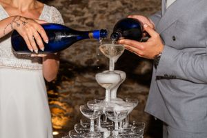 Champagne being poured into stacked glasses creating an elegant tower effect.