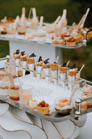 Elegant appetizer display with caviar and cork-topped glasses on silver trays.