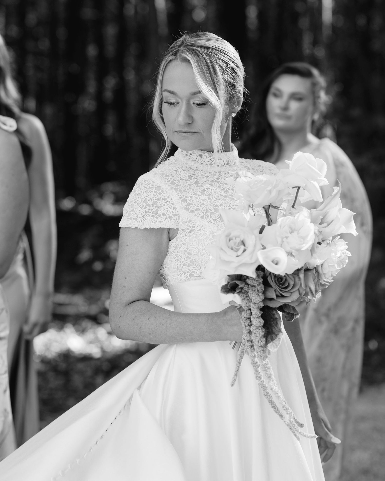 A black and white wedding photo featuring a detailed white bridal gown with lace accents.