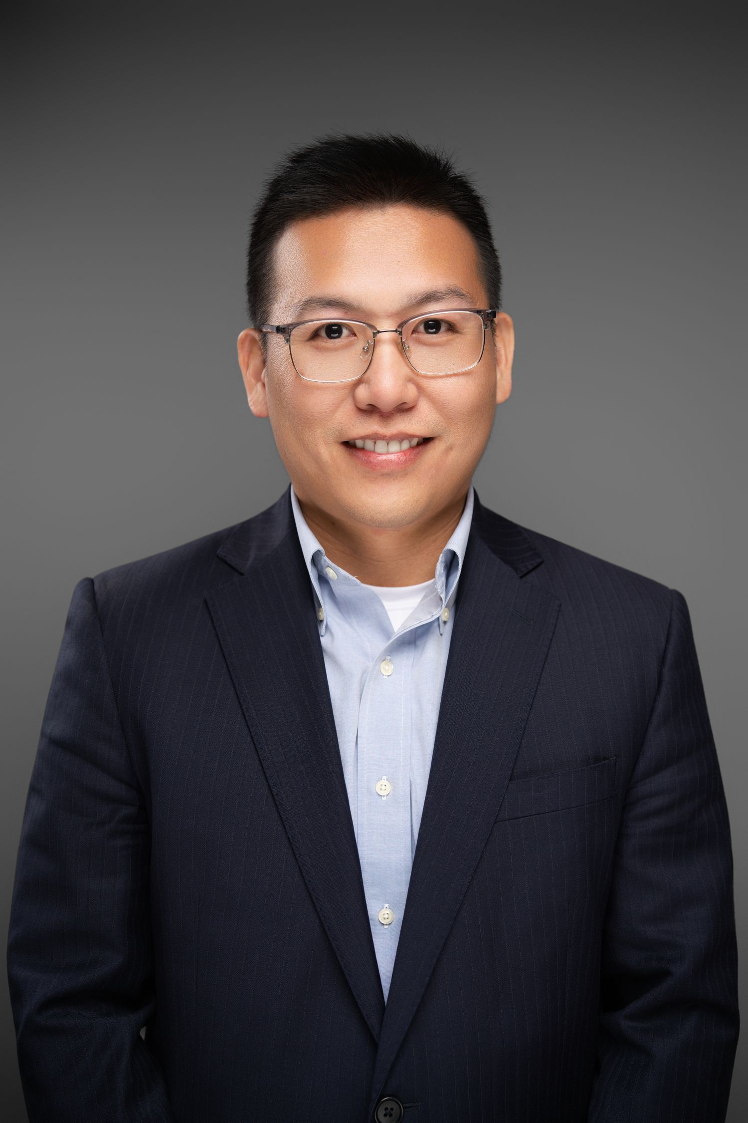 Orlando headshot photographer Ray Alvarez — financial advisor headshot in dark blazer with gray studio background