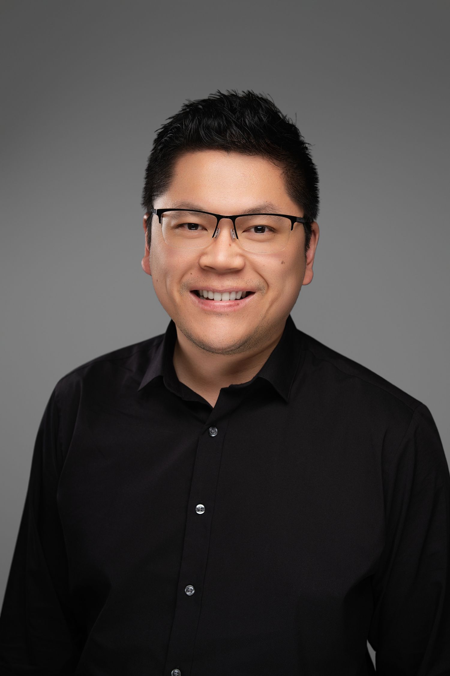 Orlando headshot photographer Ray Alvarez — tech professional headshot in black shirt with clean gray studio background