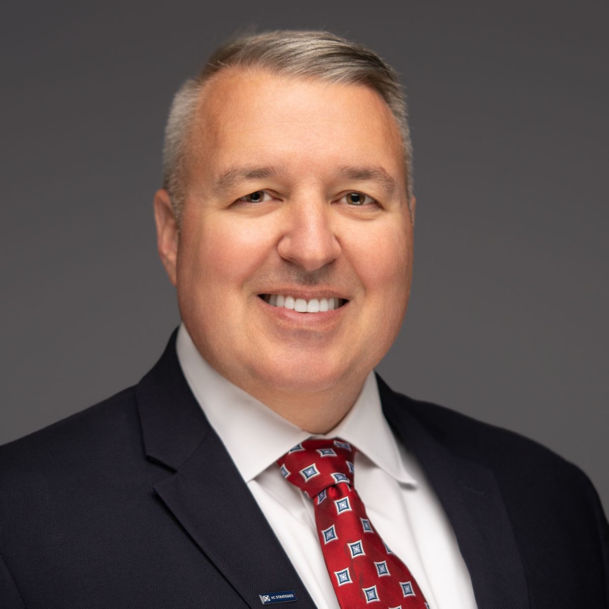 Orlando headshot photographer Ray Alvarez — corporate executive headshot in dark suit and red tie