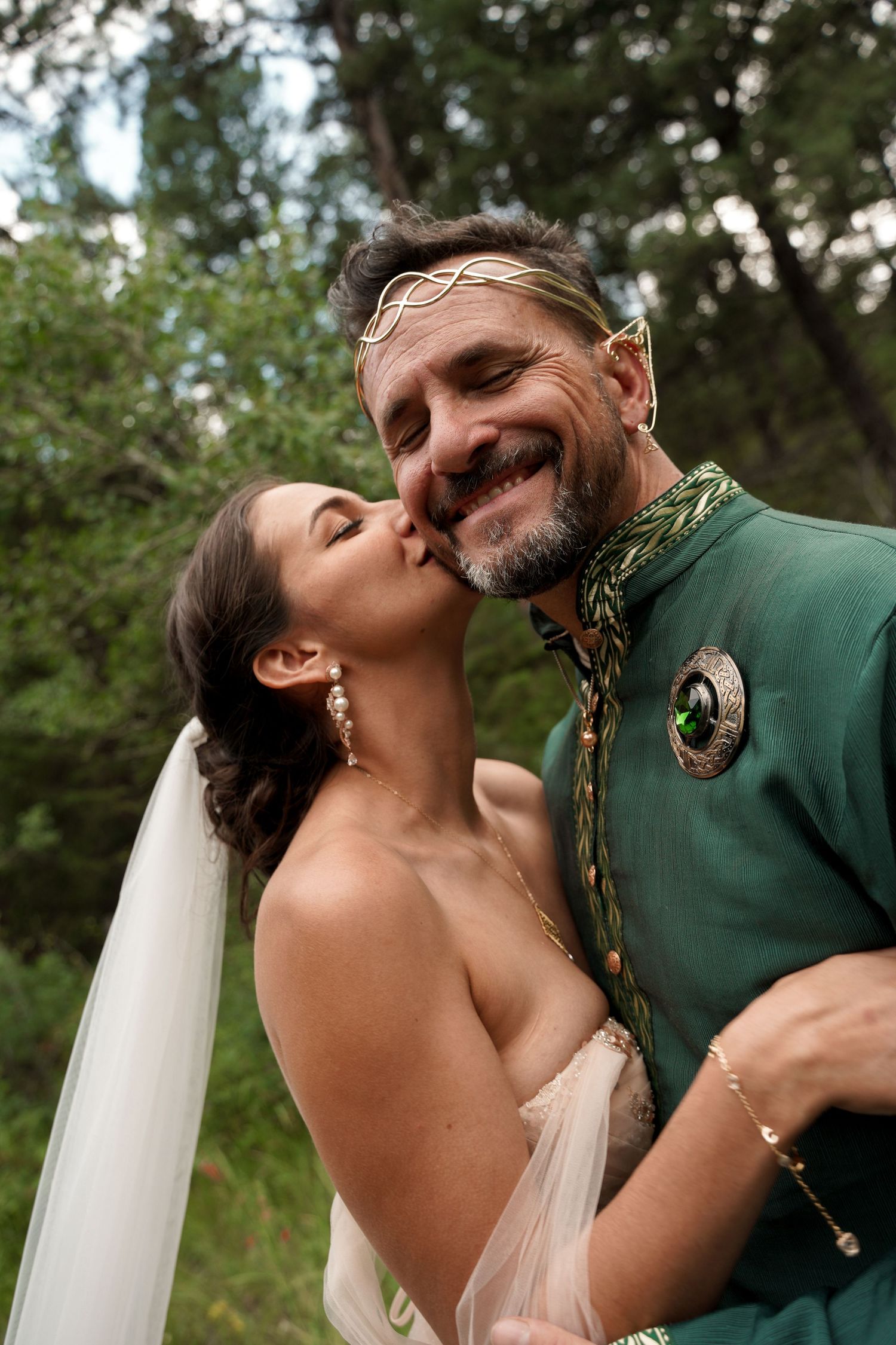 A romantic wedding couple sharing intimate kisses in a garden setting.