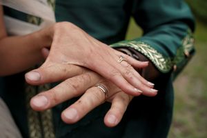 Close-up view of hands exchanging money banknotes in an outdoor setting.