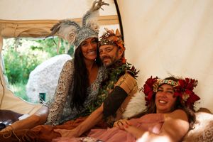Celebratory moments captured in a tent with floral decorations and natural lighting.