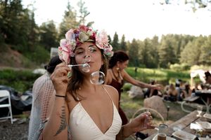 Guests celebrating with drinks and laughter at an outdoor wedding reception.