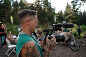 Wedding photographers with professional cameras capture moments at an outdoor ceremony.