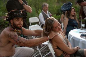 Festival attendees in medieval attire enjoy a playful moment at an outdoor event.