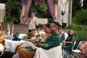 Outdoor wedding reception setup with tables and decorations in a natural setting.