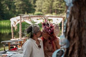 A close moment between two people during an intimate outdoor celebration under a decorated canopy.