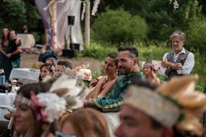 Wedding guests seated outdoors watching a ceremony surrounded by natural greenery.