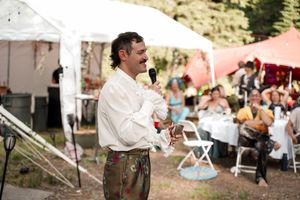 Festive outdoor celebration with white tents and guests enjoying the gathering.