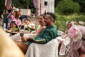 An outdoor reception with elegant table settings and natural woodland backdrop.