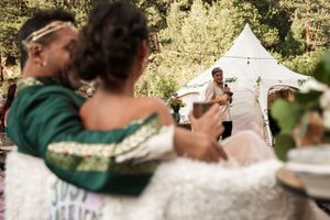 Wedding photographers documenting a celebration in an outdoor forest setting.